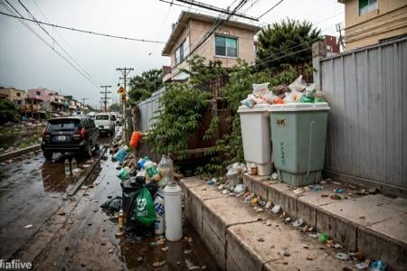 RAW photo,subject,8k uhd,dslr,soft lighting,high quality,film grain,Fujifilm XT3,,ruanyi0042,no humans,bottle,box,bucket,building,cardboard box,cup,fence,food,lamppost,paper bag,plant,plastic bag,power lines,road,rubble,ruins,soda can,street,traffic light,trash bag,tree,window,,<lora:0042 garbage city_v2:1>,<lora:detail_slider_v4:1>