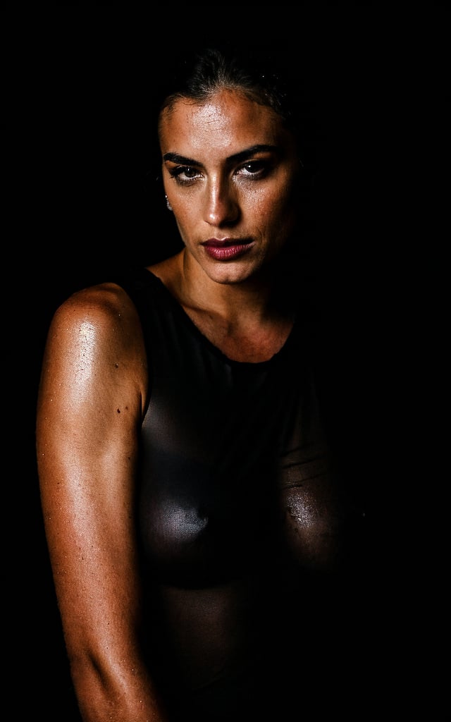 stunning photo, dark portrait of sexy beautiful woman, wearing wet black tshirt, covered nipples, in a black background, rain, dimly lit, low key, rim lighting, soft lighting, Fujifilm XT3, 8k, sharp focus