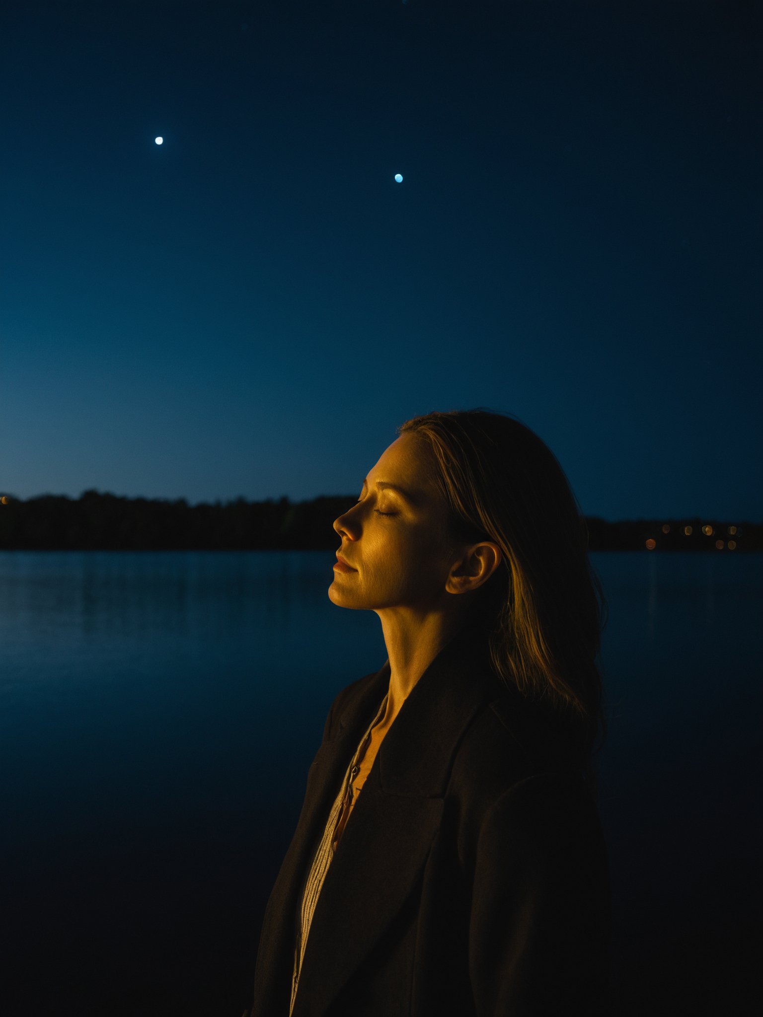 a woman standing in front of a body of water at night with her eyes closed and her head tilted, cinematic photography, a character portrait, figuration libre,rim light,