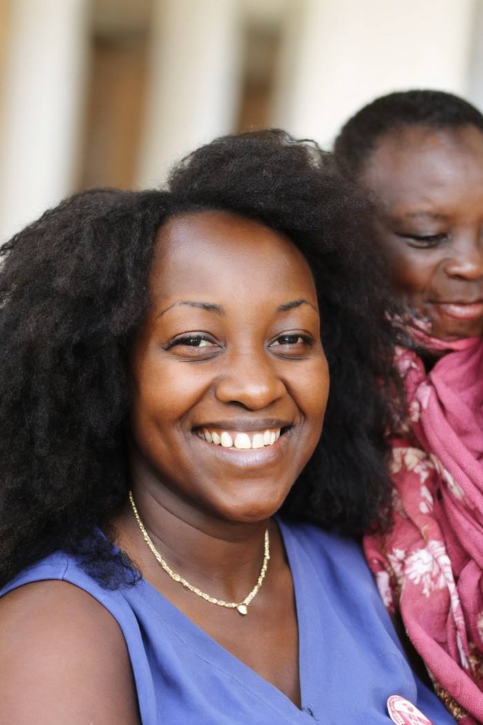 photo of a woman, Kenyan, head tilted with a smile, nurse