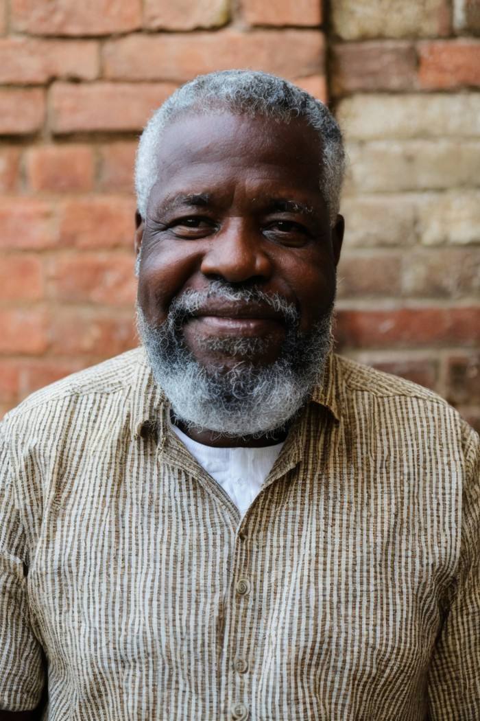 photo of a man, Haitian, middle-aged with graying beard, doctor