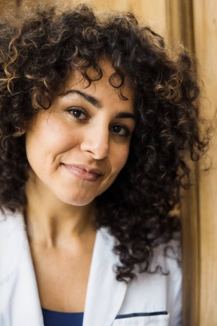 photo of a woman, Chilean, face framed by curly hair, doctor