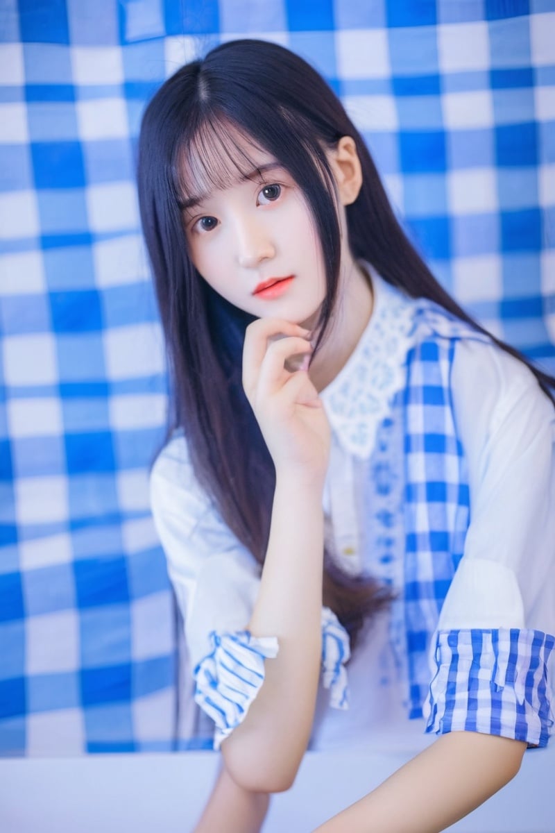 1girl, chinese girl sitting at a table with a checkered tablecloth, clothed in white shirt, with a blue background, sitting on a bed, white blouse, young woman with long dark hair, white hime cut hairstyle, with a cool pose, 18 yo