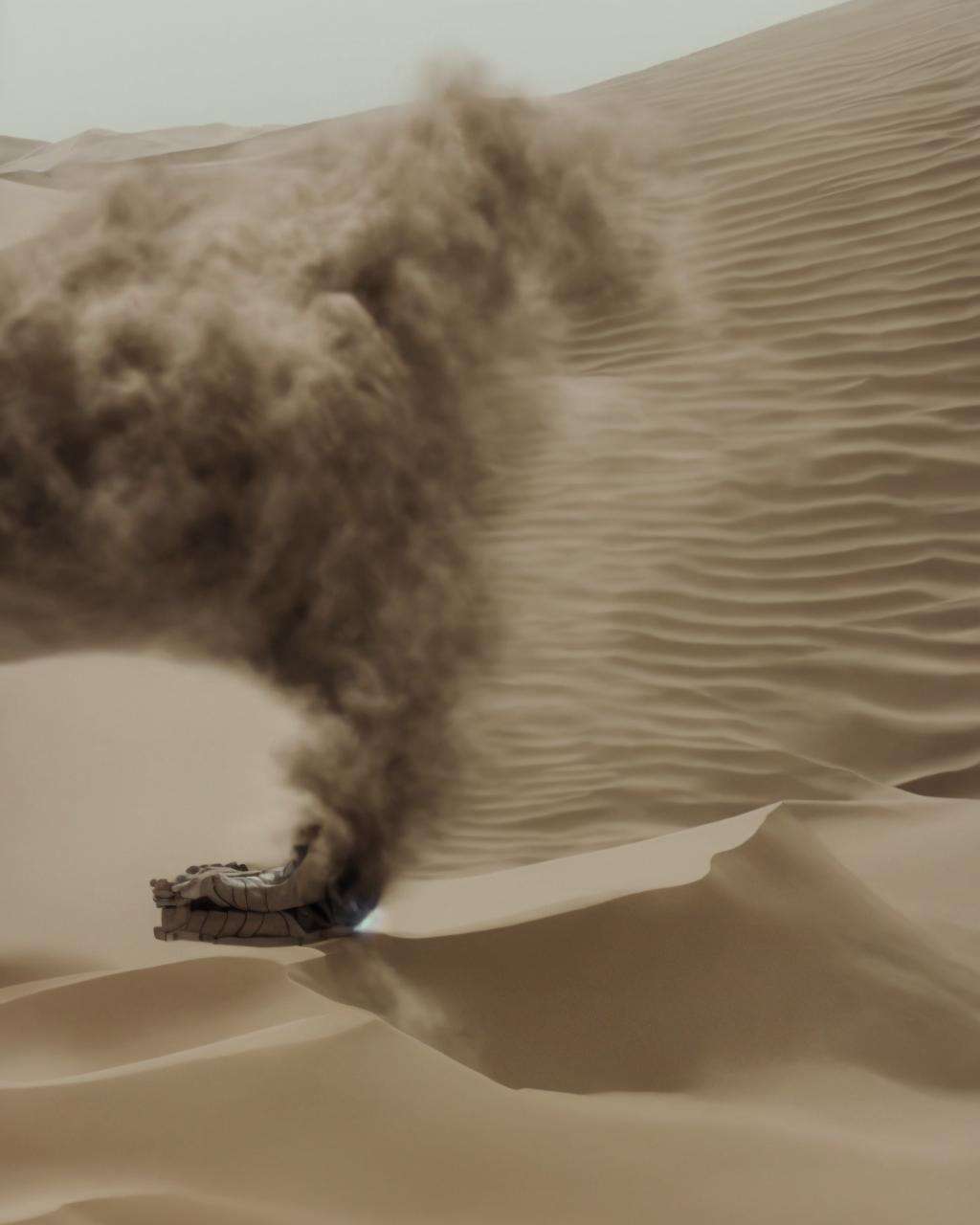 a truck driving through a desert with sand blowing up