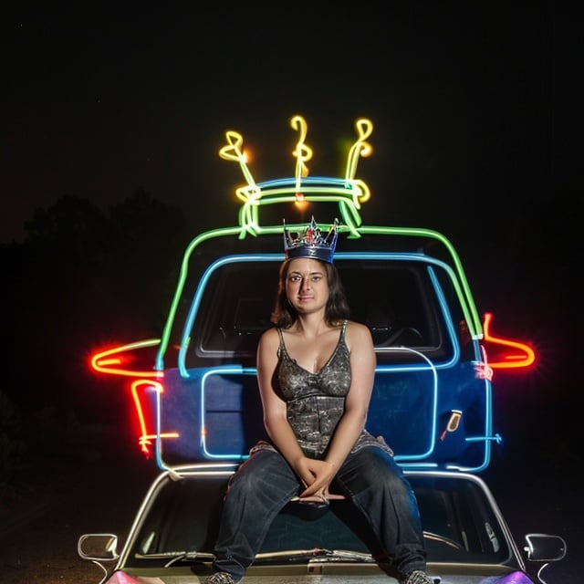 light_painting, neon lights, neon, lights, a woman sitting on a car with a crown on top