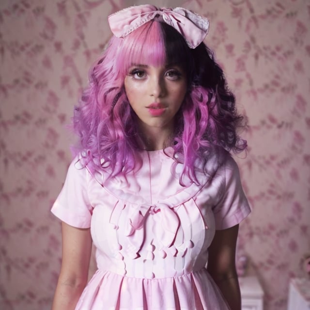 a woman, arianna, pink and black split dyed hair, light pink dress