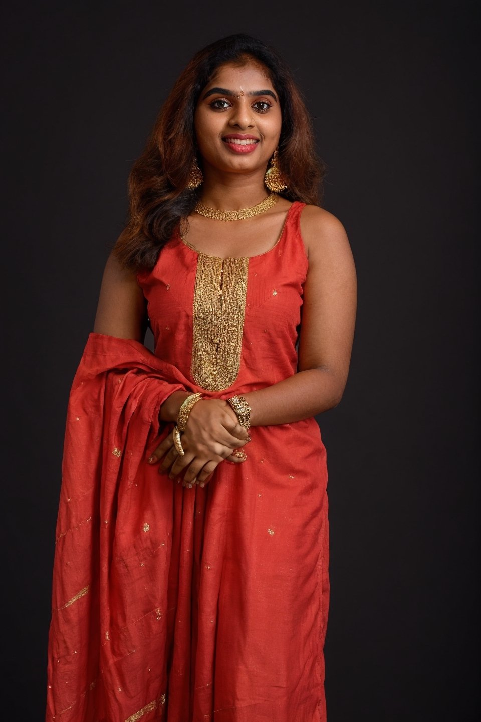 20 year old indian woman,  thick waist, long curly brown hair, gold jewels, front view, movie scene, cinematic, high-quality, ultra-detailed, professionally color graded, professional photography.  ( hard light:1.2), (volumetric:1.2), well-lit, double exposure, award-winning photograph, dramatic lighting, dramatic shadows, illumination, long shot, wide shot, full body, at studio, smart watch on left hand, happy_face, Fast shutter speed, 1/1000 sec shutter, golden_jewelry, embroidered traditional indian dress, , salwar, red cloth, sleeveless, dark background,Mallu,Paru