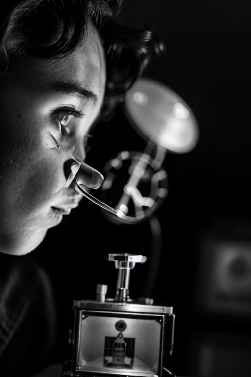 candid still photograph of a kid watching somehting called a "Smellavision" which makes terrible smells, 1950's, black and white high contrast photograph, suburbs, mid-century, micky ears, robot smoking, realistic