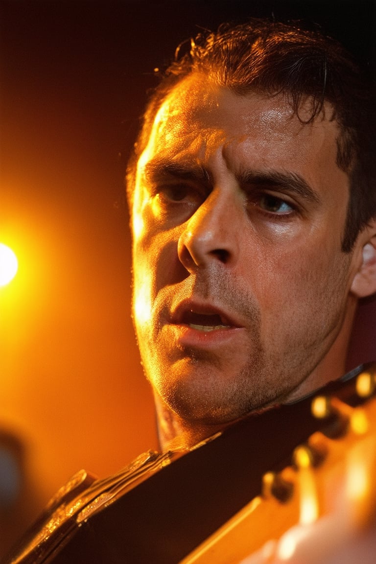 A dramatic close-up shot of Jero's face, with a hint of sweat glistening on his forehead as he intensely plays the electric guitar. The stage lights cast a warm orange glow, highlighting the curves of his instrument and the determined look in his eyes.