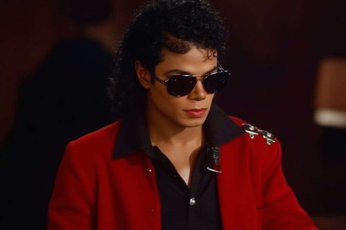 Michael Jackson wearing a dark red tuxedo with sunglasses 