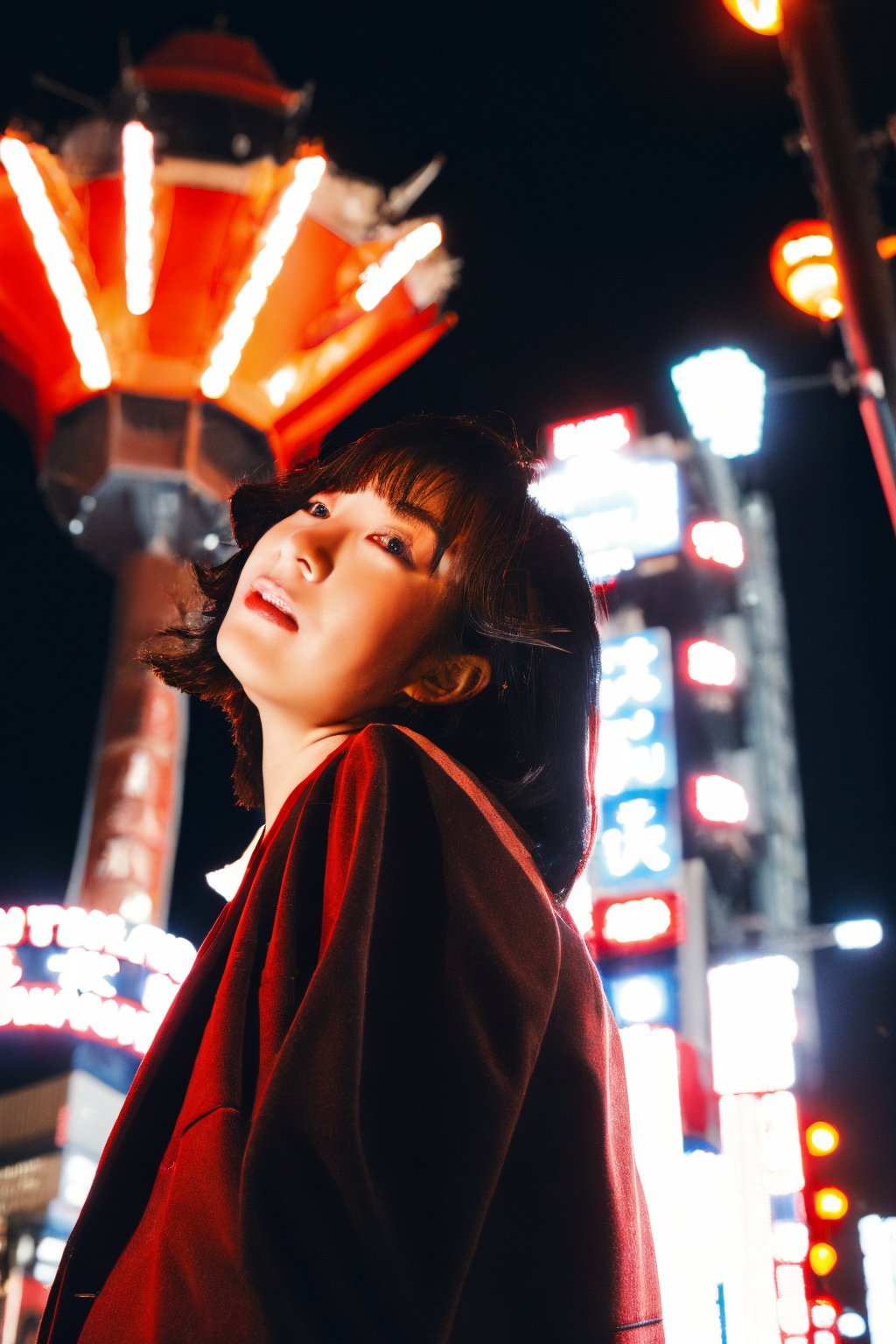 A young Asian woman, short hair, wearing a red jacket and a white t-shirt with Japanese text, necklace, standing on a Tokyo street at night, with Tokyo Tower in the background, illuminated city lights, red lanterns, urban style, night photography, candid pose, low angle shot, with a hint of film grain.

,fujifilm