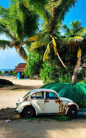(best quality, 4K, 8K, high-resolution, masterpiece), ultra-detailed, Stunning visuals of a photorealistic image: close_up, (((A rusty and broken white Volkswagen Beetle sits beside an east Malay traditional wooden house))), (((surrounded by the tranquility of a beach and fishing village))). The composition is dynamic, with the beetle's curves contrasting the angular lines of the house. A park boat drifts gently in the distance, while coconut trees sway above. A rhu tree stands tall, its branches tangled in a net. The blue sky above provides a cool color palette, as the camera captures both a close-up shot of the beetle and a wide view of the serene scene.
