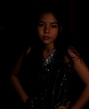 A close-up shot of a young girl standing in a dimly lit room, wearing a sleek black dress that hugs her curves. The dress is adorned with intricate silver sequins that catch the faint light, giving off a subtle sparkle. Her long dark hair cascades down her back like a waterfall, framing her heart-shaped face. She stands confidently, one hand resting on her hip, as if savoring the moment