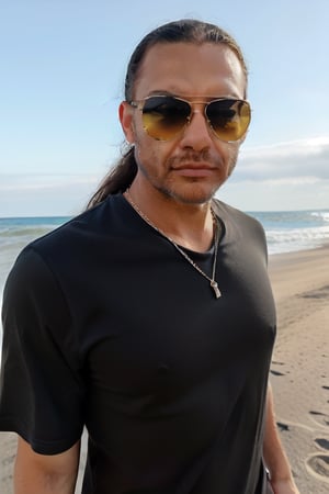 man long hair black shirt with sunglasses on a beach