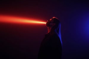 CridLight, cover face mask,
A moody, atmospheric portrait of a person, captured in a side profile. The subject is illuminated by a radiant beam of light that cuts across the scene, casting a spectrum of colors ranging from deep reds and purples to bright blues and yellows. The person's pose is contemplative, with their head tilted upwards and eyes closed, suggesting a moment of introspection or wonder. The individual is dressed in a dark, possibly black, outfit that contrasts with the luminous background. The lighting creates a dramatic and ethereal atmosphere, emphasizing the interplay of light and shadow. The background is dark, which accentuates the luminosity of the light and the subject, creating a sense of depth and dimension. The overall style of the image is evocative and evocative, with a focus on mood and atmosphere over detailed realism.