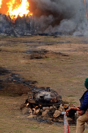 indian doctor, battlefield, burning watertank in background, vintage look, sharp focus, view from ground level