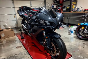 there is a motorcycle that is sitting on a stand in a garage, front side full, transparent black windshield, front perspective, chrome and carbon, translucent sss, front lit, front shot, front on, front view dramatic, motorcycle, front profile, huge ducati panigrale motorbike, yoshimura exhaust, full body wide shot, front side, samurai vinyl wrap