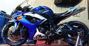 there is a blue motorcycle parked in a garage, Suzuki GSXR, side profile!!!!,