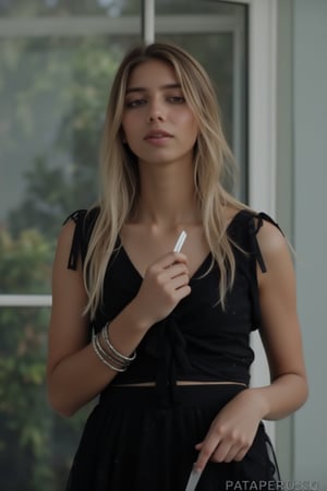 A medium-angle shot of a woman in a black dress, adorned with black polka dots, stands in front of a glass window. The woman's left arm is draped in a silver bracelet, while her right hand is holding a silver knife. The background is blurred, suggesting a natural setting. The text "PATAPERUKKI in" is written in a watermark in the upper right corner of the image.