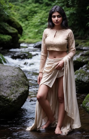 The task is to annotate the image by identifying and describing its content using natural language. The image contains a woman standing in a natural setting, which includes a stream and rocks. She is dressed in traditional attire with a red blouse and a white skirt, adorned with gold detailing. Her pose and the serene environment suggest a connection with nature and possibly a cultural or personal significance to the attire and setting. 