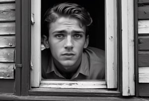 A detailed black and white portrait of a handsome young man, shown from the waist up. The person is peering through an open window, with a sharp focus on the facial expression. Beyond the window, outside are overgrown buildings in various states of neglect and decay, photorealism,Extremely Realistic