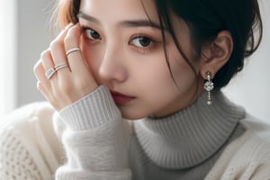 a close up of a person of woman wearing a ring, with a white sweater on, hand_holding_touching an earing, have a light shining on her face,shorthair_jewelery, background_flat_grey