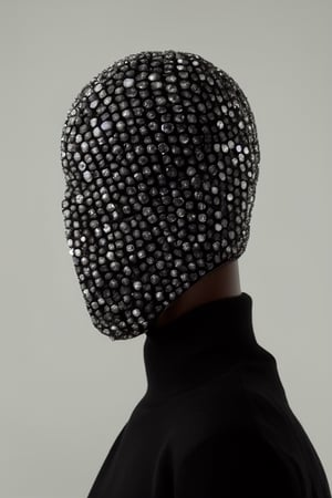 Black and white photography of a woman with a black hooded mask adorned with diamonds and a black turtleneck