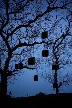 Picture eerie trees adorned with numerous cathode ray tube televisions hanging from their branches like strange fruit. The gnarled limbs of the trees twist and contort, creating a haunting silhouette against the dimly lit sky.Each television emits a faint glow, casting an otherworldly light on the surrounding area. The screens flicker with static and distortion