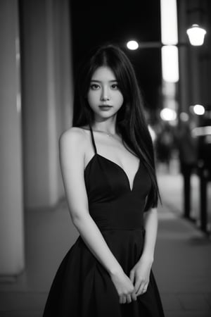 A woman in a black evening dress, glamor, black and white photography, elegant pose, blurred background.