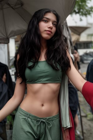 A 15-year-old girl with long brown hair and bright green eyes stands confidently outdoors, her skin glistening from the sunlight. She wears short hot pants and a subtle upper, her lips curled into a gentle smile as she gazes directly at the viewer. A delicate flower adorns her navel, its petals slightly blurred by the camera's focus on her captivating gaze. Her brown hair blows gently in the wind, framing her freckled nose. In the background, a slender branch reaches out, almost touching her shoulder. A slim-fit energy light particle mecha hovers near her head, its sparks and particles dancing around her in shimmering harmony.