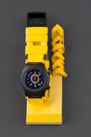 A G-Shock style watch with a black and yellow colorway. black dof domminant, The watch is made of durable materials and is water resistant to 200 meters. It has a digital display and a stopwatch function. Displayed on the box, rubber band