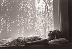 lith_argenta_bromBN1W. B & W Photo of a patterned illumination casting a tree branch shadow a blonde woman, sleeping peacefully in the morning sunlight. The rays stream through a window, casting gentle shadows around her face, accentuating her full lips and soft features