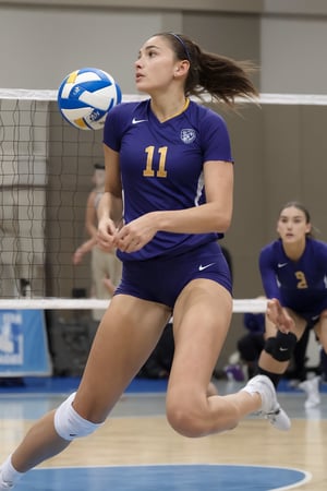 Tall and athletic Ukrainian volleyball player stands confidently on the indoor court during a lively practice session. Her long, dark brown hair falls down as she gazes intently at her teammates. She wears a fitted volleyball jersey and matching shorts, showcasing her toned physique. The camera captures her in mid-stride, frozen in motion, as if preparing to make a powerful serve or block.