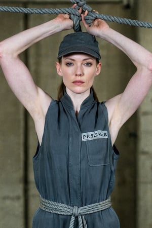 close up upper body portrait of a very pale female prisoner  with a very athletic body, standing up straight  wearing a dark grey cap_sleeved sleeveless prisoner jumpsuit, during the photoshoot both of her arms are tied above her head by ropes, deep hollow armpits, 

remember both arms are raised up as they are tied 