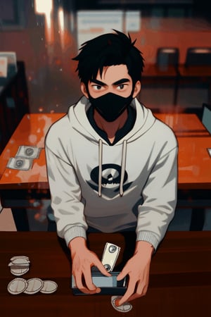 young hoody guy, with a punisher mask,playing with money, front of a desk sitting and looking to the camera. 