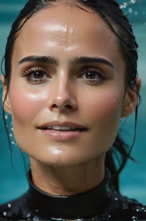 Jordana Brewster, emerging from the water. Her head and shoulders are visible above the surface of water. She looks surprised but smiling, her black turtleneck top wet and clinging to her, with water droplets sparkling around her. She is in the middle of an indoor pool and splashes from her emergence, fully drenched, dripping wet, wet hair, face wet, face drenched