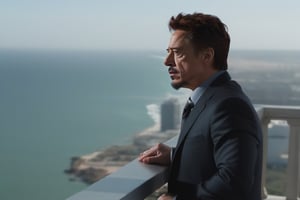 Tony Stark pensativo, observando el horizonte desde el balcón de su mansión. Toma panorámica