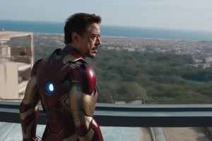 Tony Stark pensativo, observando el horizonte desde el balcón de su mansión. Toma panorámica