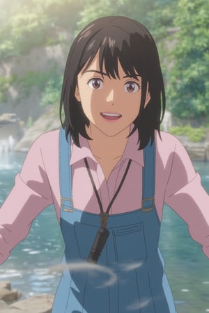 a young Asian girl with dark brown hair, wearing a light pink long-sleeved shirt and a blue jean overalls. She is smiling, with her arms stretched out in front of her. The background is blurred, suggesting a natural setting. The girl's eyes are slightly open, as if she's looking at the camera. She has a black microphone attached to her shirt, adding a pop of color to her outfit.,freya_jkt48