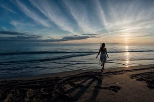 a wide and paradisiacal beach of fine white sand, when it is still night and beginning to dawn. Different tones in the sky, from the dark of the night to the light of the new day. ,Beautiful Beach, a girl walking to the camera on the beach, the girl showed just upper side