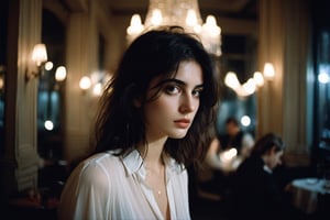 create a beautiful woman in a crowded french restaurant at night , waiting for someone, melancholic, sad, natural colours, long black hair,messy hair, short hairs, 25 years old, natural skin, extremely detailed,photo r3al,aesthetic portrait, wide shot,(cinematic),no teeth, no sun, in a white blouse, ((night)), warm string lights, candle light, chandelier, 35mm, vogue magazine, film, paris