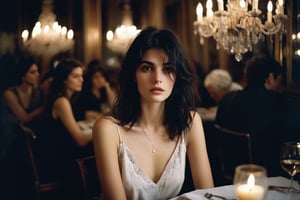 create a beautiful woman in a crowded french restaurant at night , waiting for someone, melancholic, sad, natural colours, long black hair,messy hair, short hairs, 25 years old, natural skin, extremely detailed,photo r3al,aesthetic portrait, wide shot,(cinematic),no teeth, no sun, in a white blouse, ((night)), warm string lights, candle light, chandelier, 35mm, vogue magazine, film, paris