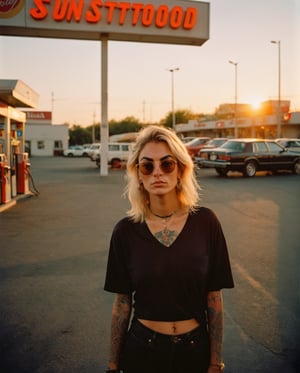 Instagram street-style photo of a a woman wait at the gas station, 30 year, Rayban sunglass, sunset, black shirt, blond hair, multi-colored hallow eyes, only 1 arm fully tattooed shot on Kodak Ektar 100, soft lense, mid-full length,analog