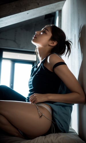 Shot from a low angle, looking up at the young woman's precarious perch on the edge of the bed. Artificial light casts a flat, shadow-less glow, illuminating her frantic expression and highlighting the confinement of the small space. The windowless walls seem to press in, amplified by the eerie lighting that accentuates her distress.