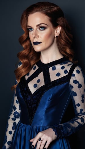 a white woman with reddish brown hair, with streaks of black in it. she's wearing a dark blue silk and lace gown with black trim. her makeup is black and her finger nails are dark blue. full body photo. 