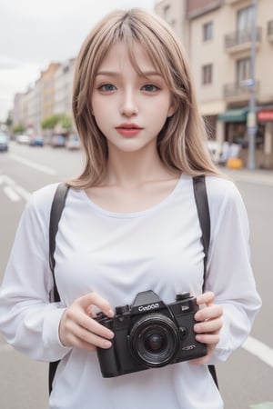 An animated image of a girl with long blonde hair and blue eyes. She is wearing a white long-sleeved shirt with a black strap over her shoulders. The girl is holding a black camera in her hands. The camera has a black lens and a white label on the front of it that says "Canola". She is standing on a city street with buildings in the background.
