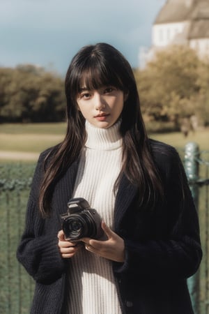 1girl, solo, looking at viewer, bangs, black hair, long sleeves, holding, upper body, outdoors, parted lips, open clothes, day, medium hair, blurry, black eyes, sweater, lips, coat, blurry background, turtleneck, turtleneck sweater, realistic, fence, camera, photo background.