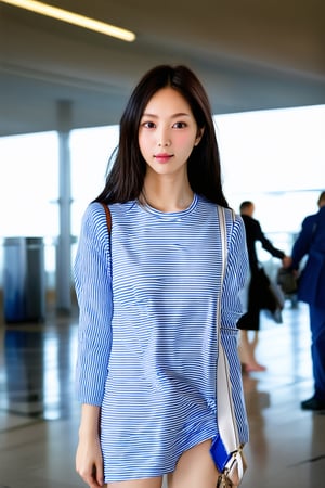 a woman wearing a blue and white striped shirt in an airport