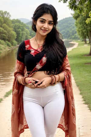 a smiling cute indian woman in her 20s with a fair skin tone and braided hair, wearing a red velvet saree, white legging and wearing a black sandals. simple smile, background near lake, full size image, widen her legs