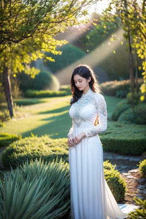 The image depicts a person in a white dress with their face obscured, standing outdoors amidst ethereal lighting. The person is wearing a long, white dress with intricate designs on the sleeves. Their face is obscured by a blurred square, making identification impossible. They are standing in an outdoor setting that appears to be a garden or forest, with trees and rocks visible in the background. Ethereal beams of light filter through the trees, casting an otherworldly glow on the scene. There's a mystical or serene atmosphere created by the combination of natural elements and lighting.